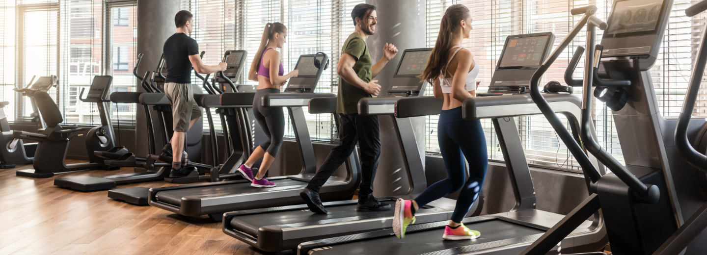 a group of people running on treadmills