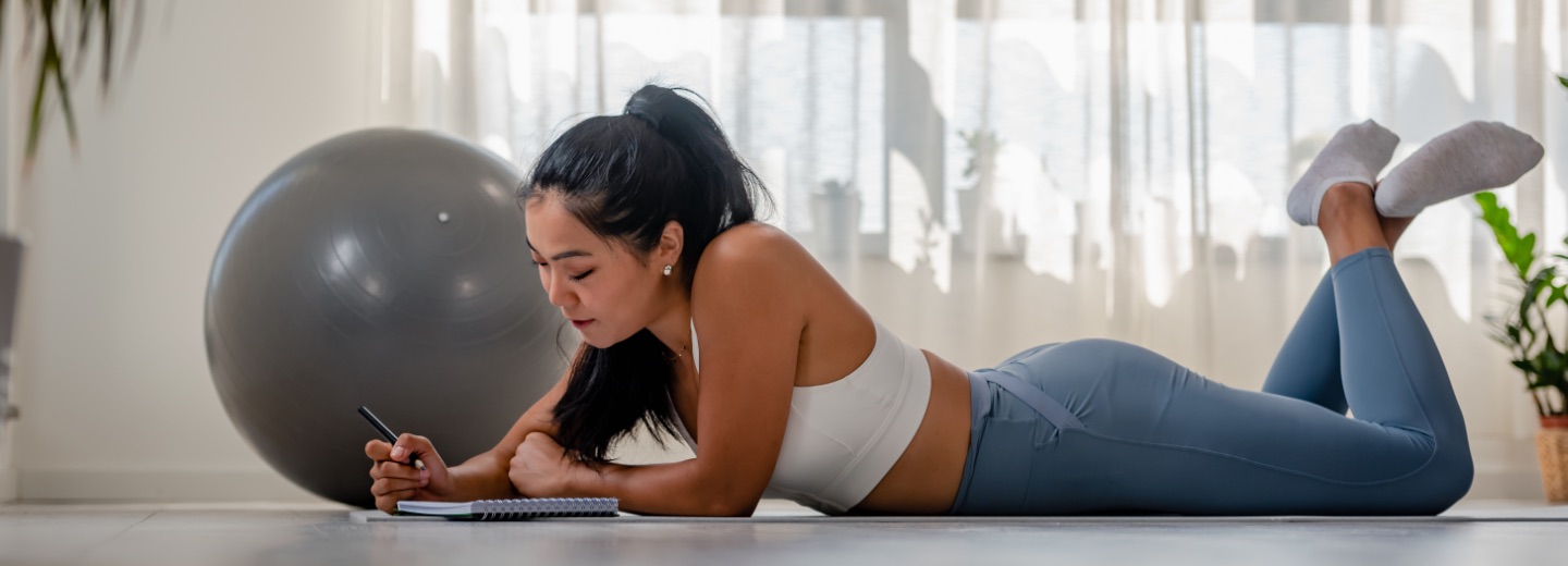 a woman writing her fitness goals