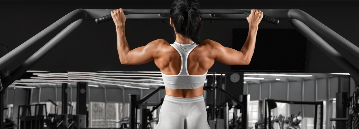 a woman in doing pull-ups on a bar